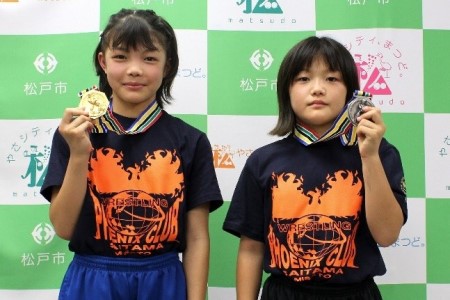 メダルを掲げる吉田のあさん、れいさんの写真