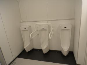 男子トイレ内小便器の写真。1箇所に手すりがついています。