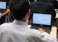タブレットパソコンで学習する中学生の写真