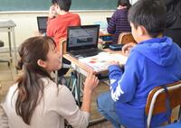 タブレットを利用し話し合う教員と生徒の様子の写真