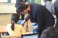教員が児童のタブレットを指さしながら一緒に学習する様子の写真