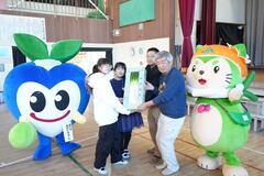 矢切ねぎを農家から生徒に渡している写真