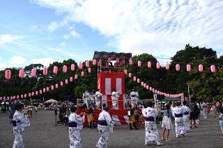 やぐらの周りを踊る人たちの写真