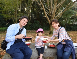 森をバックにラーメンを食べている親子連れ