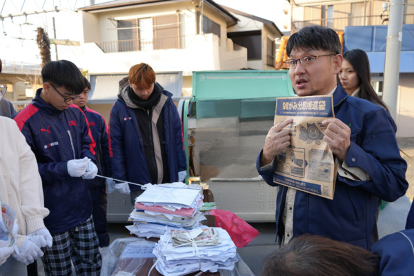 市の職員がベトナム人留学生にごみの分け方出し方を説明している