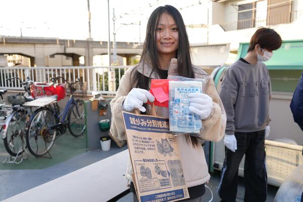 ごみの分別袋をもった笑顔の留学生