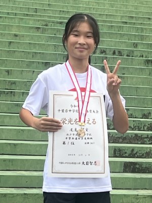 メダルと賞状を手にする尾高さん
