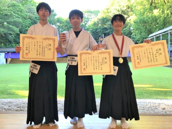 表彰状を持つ男子団体チーム