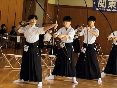 男子団体戦で弓を構える3人