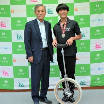 メダルを首にかけ一輪車を持つ木村さんと本郷谷市長