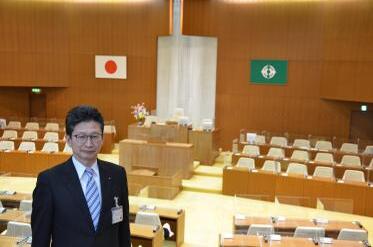 議会事務局長と議場の写真